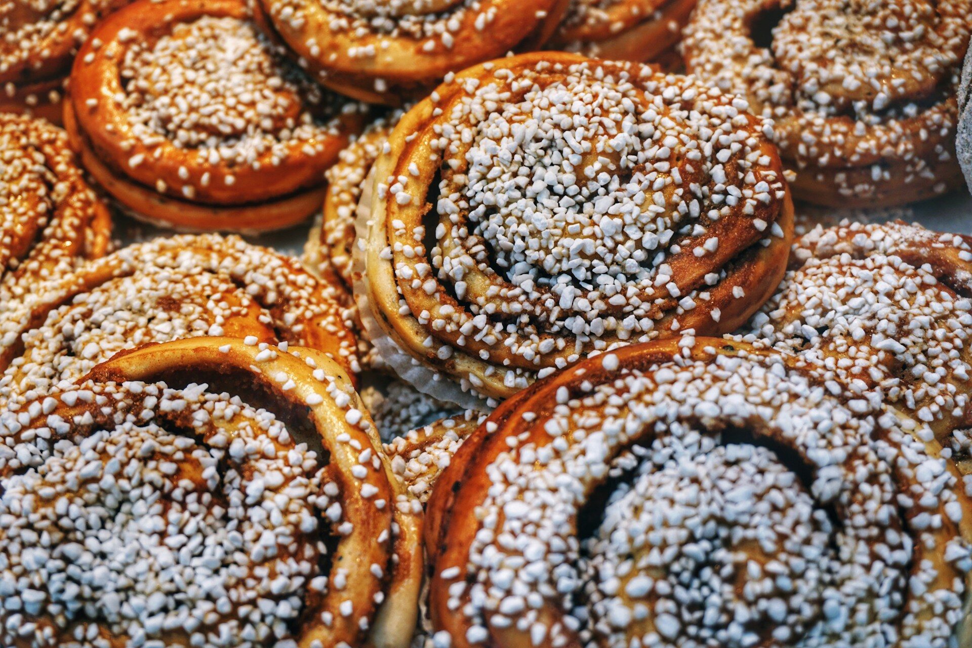 Swedish cinnamon rolls with pearl sugar topping on a baking tray